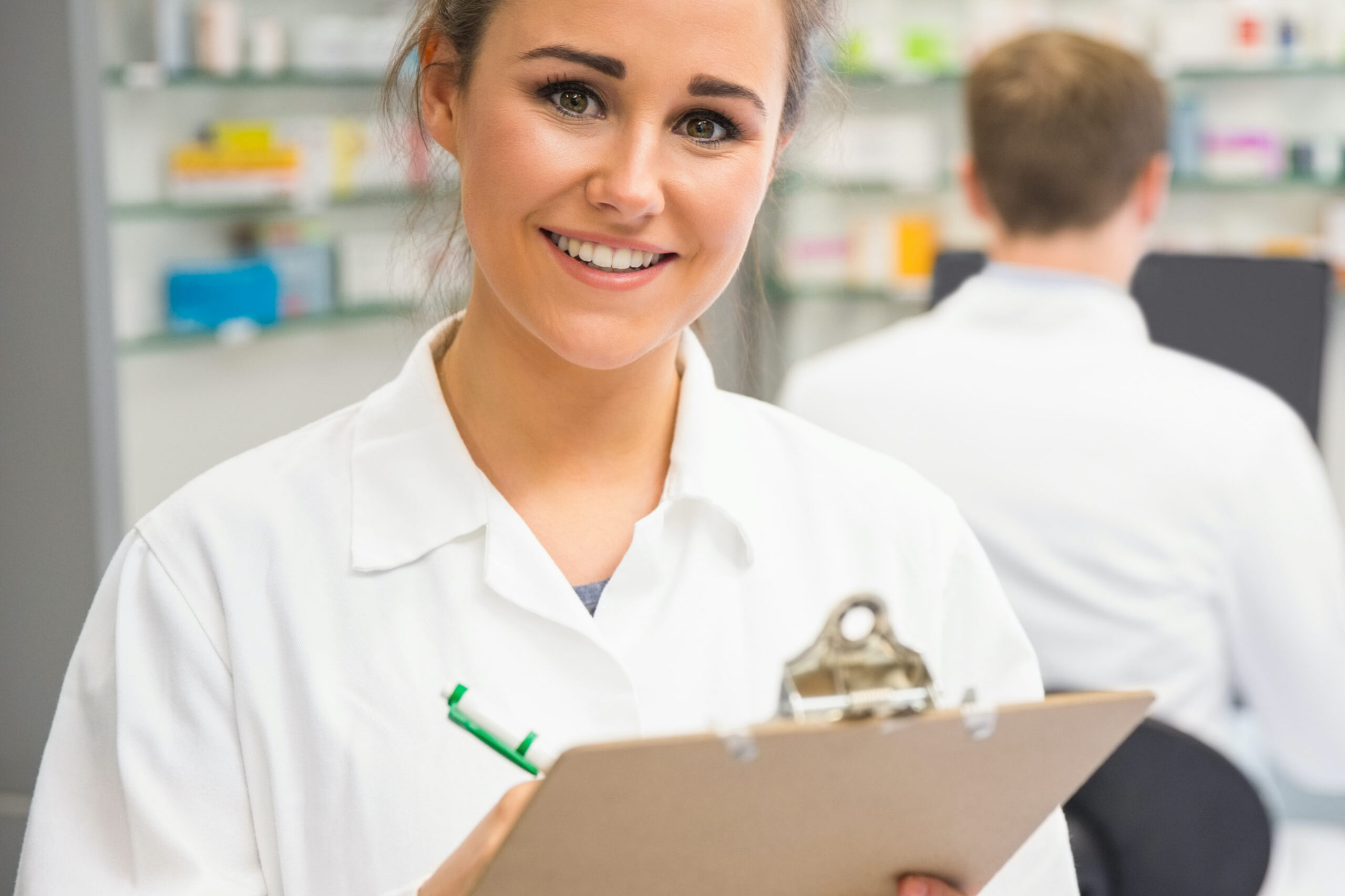 Junior pharmacist writing on clipboard